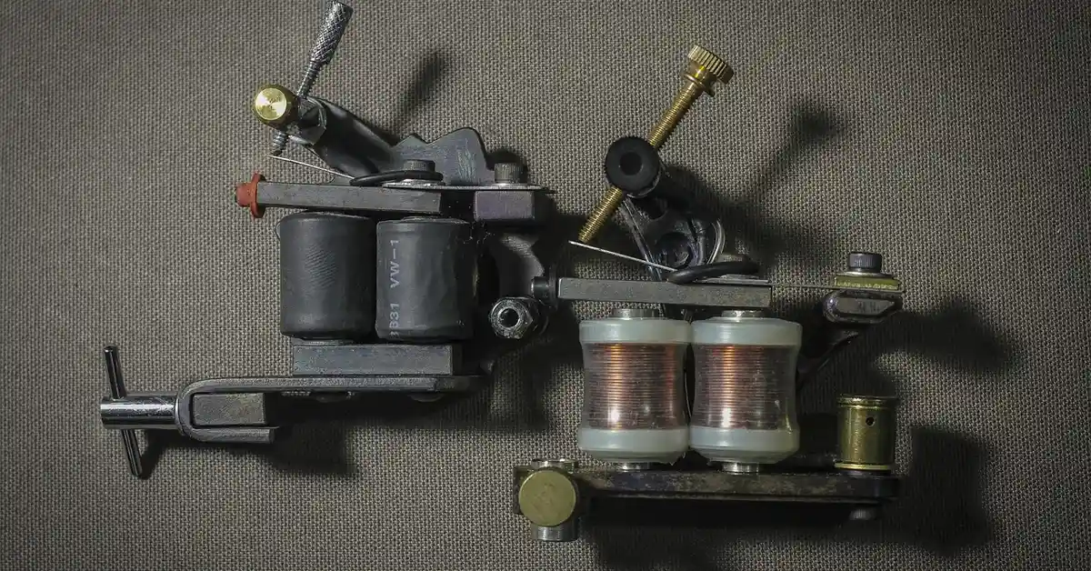 Close-up of a vintage coil tattoo machine on a dark fabric background