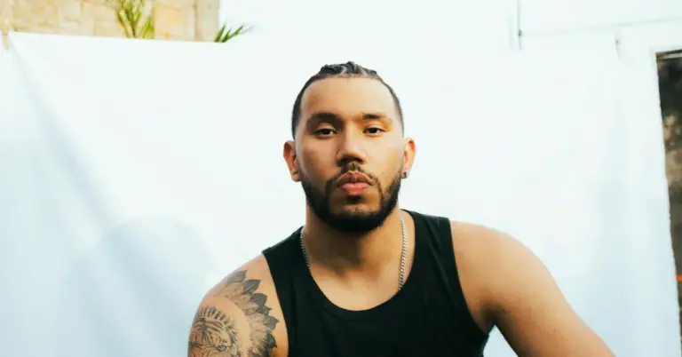 Portrait of a man wearing a black sleeveless shirt with a visible arm tattoo