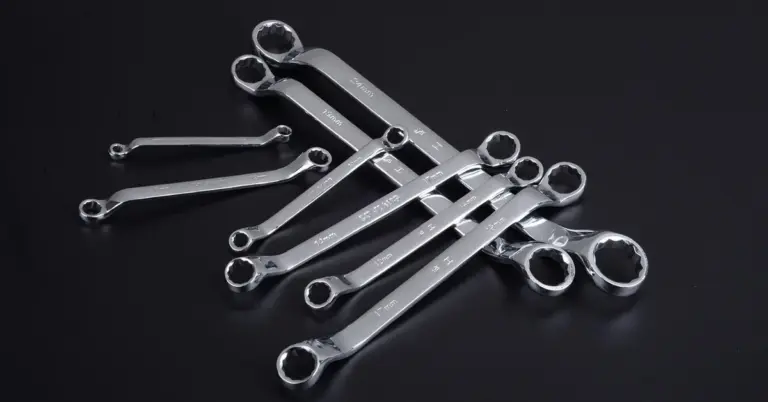 Close-up of shiny metal surgical instruments laid out on a dark surface