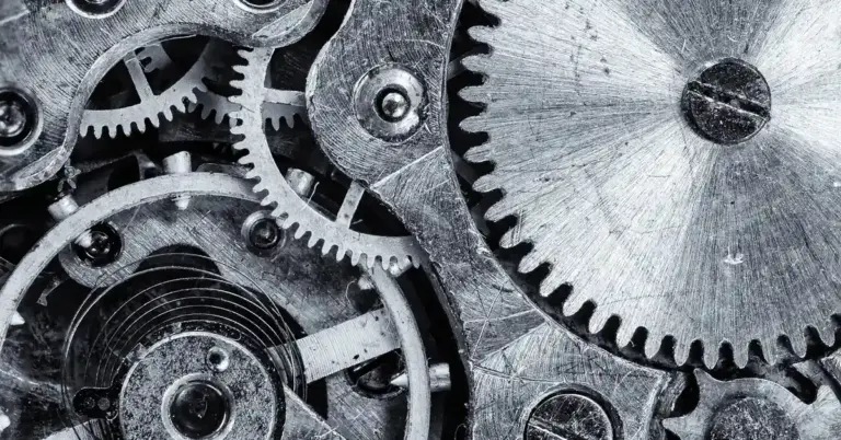 Close-up of interlocking gears and metal components, illustrating the machinery behind professional tattoo removal devices.