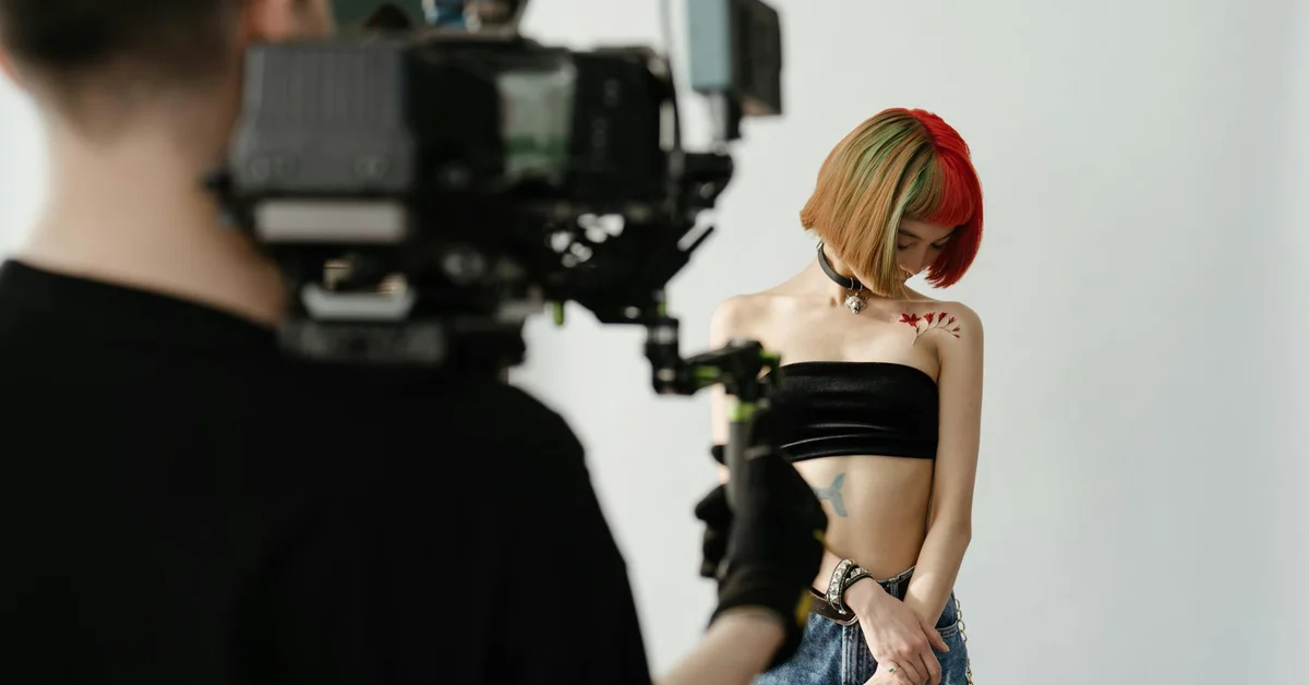 Photographer filming a model in a studio, illustrating a controlled environment related to regulatory and safety standards in tattoo removal technology