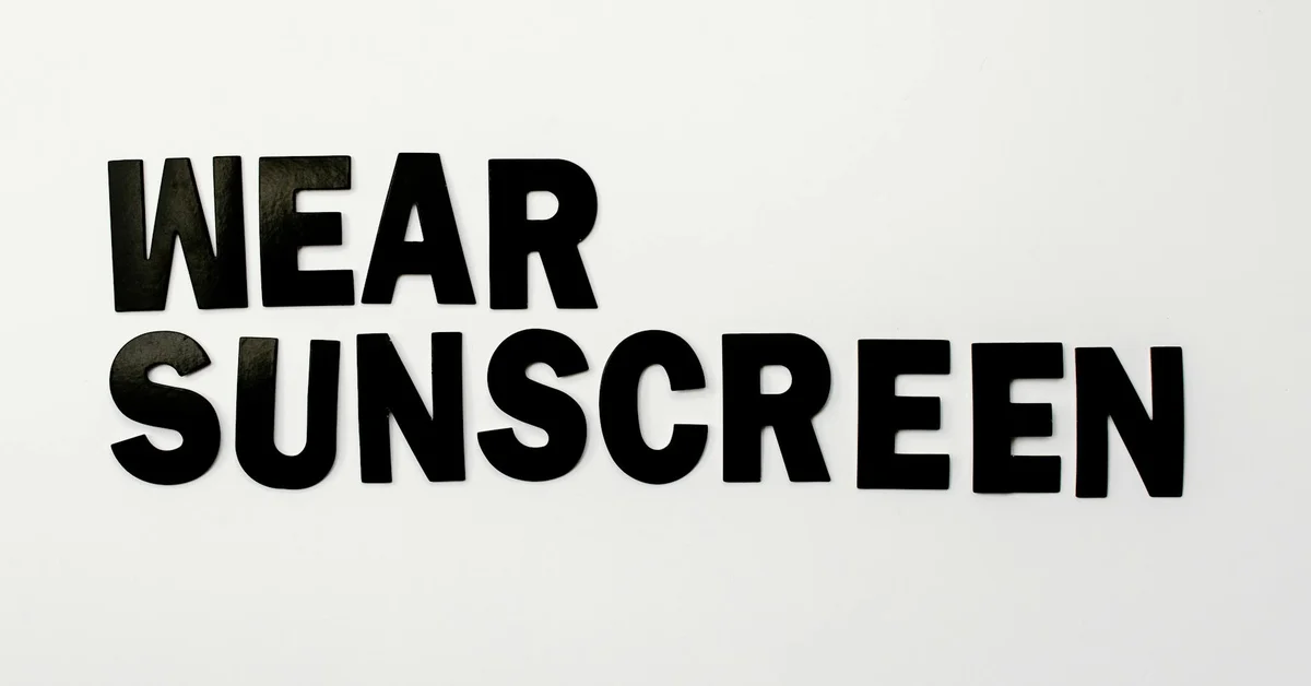Bold black text reading 'WEAR SUNSCREEN' on a light background.